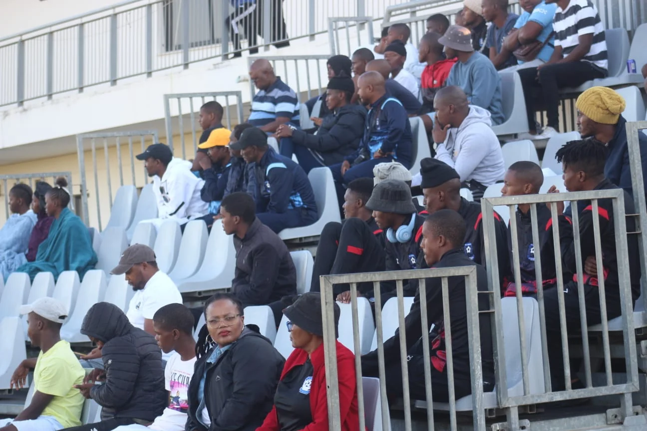 Crowd of passionate fans cheering loudly from the stadium stands