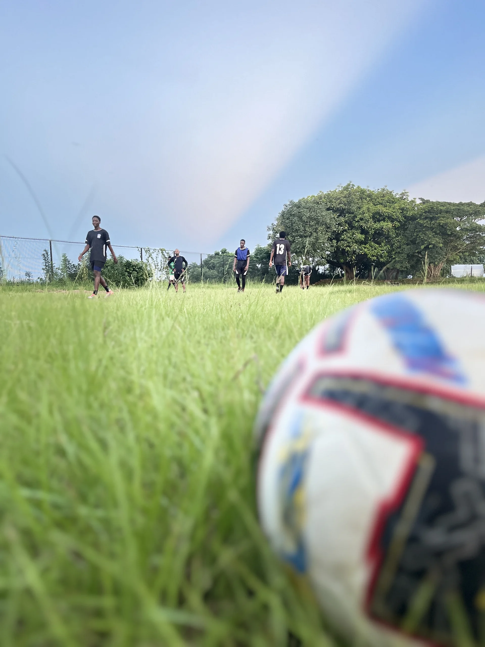 Close-up of a football resting on lush green grass ready for kickoff